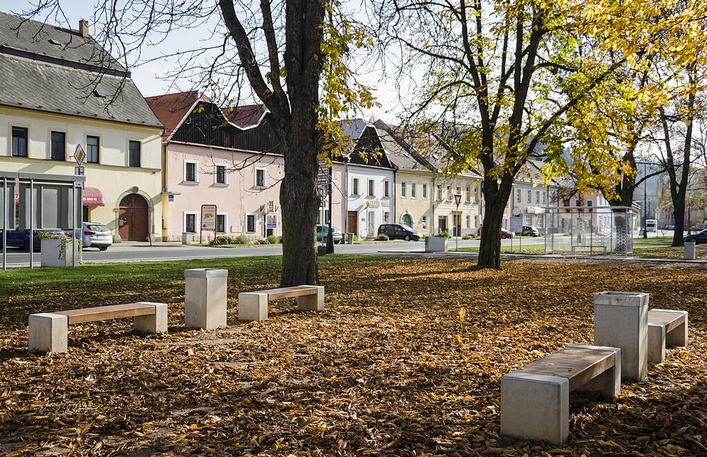 Betónové lavičky a odpadkové koše v parku